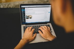 image of someone sitting in front of a laptop, typing